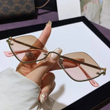 Trendsi glamorous vacation sunglasses with pink gradient lenses and gold wireframe held in hand
