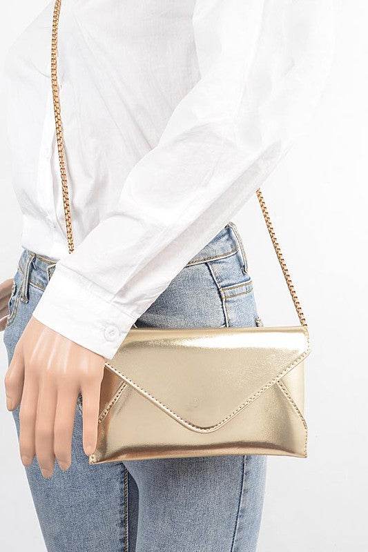 Babe Beachwear gold envelope clutch for women with chain strap worn with white shirt and jeans