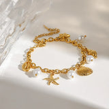 Gold ocean theme bracelet for women with gold shell charms and white pearl accents