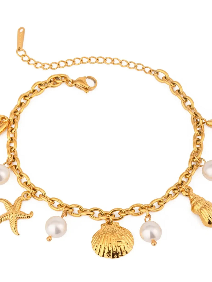 Gold ocean theme bracelet for women with gold seashell charms and pearl accents