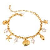 Gold ocean theme bracelet for women with gold seashell charms and pearl accents