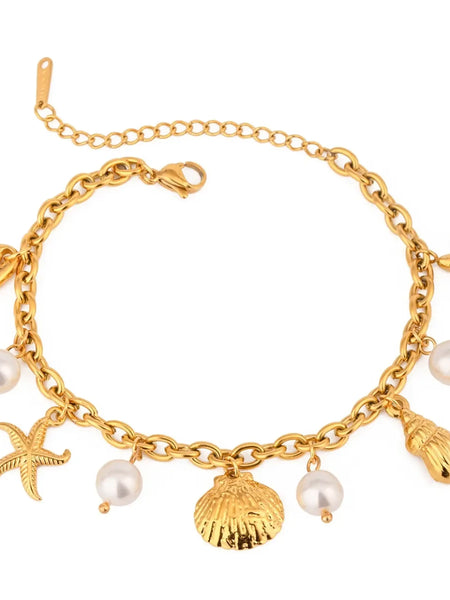 Gold ocean theme bracelet for women with gold seashell charms and pearl accents