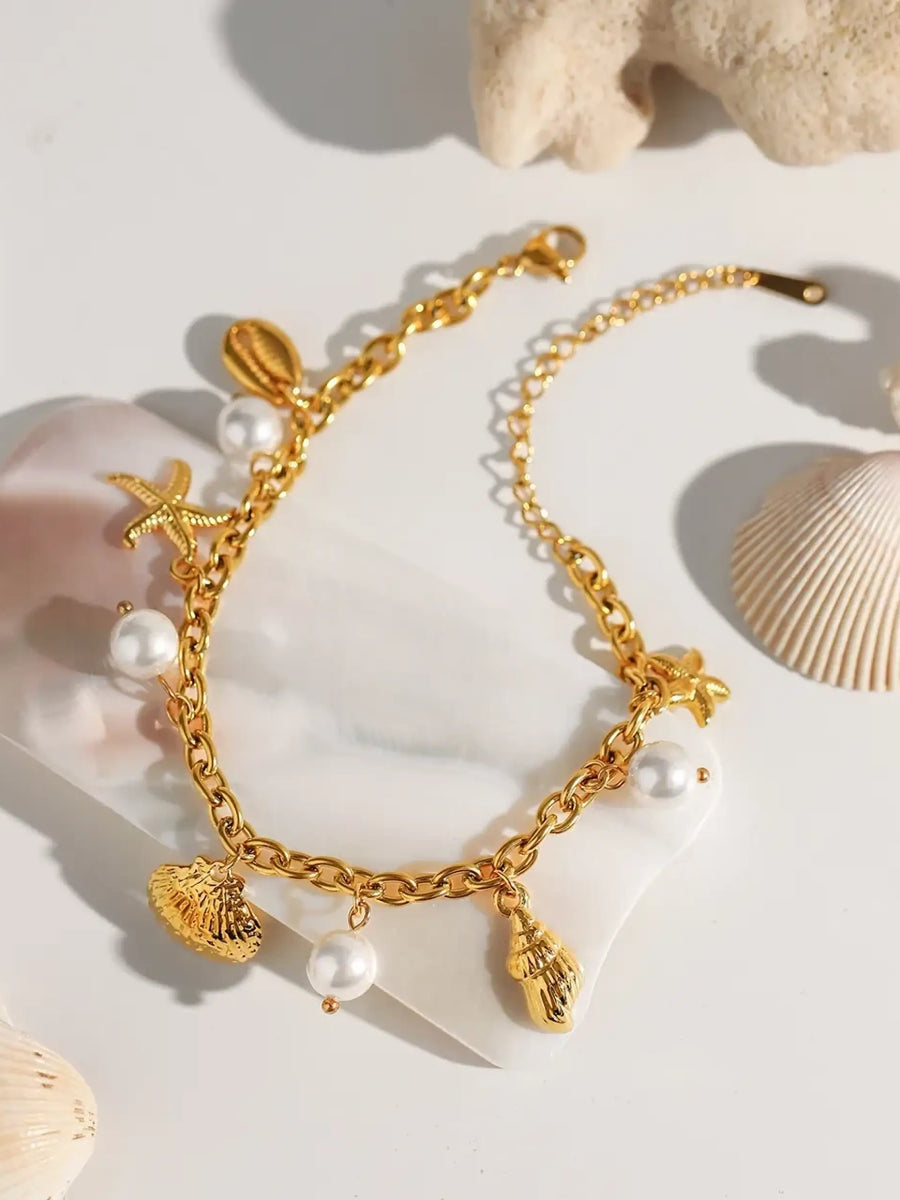 Gold ocean theme bracelet for women with gold shell charms and white pearls