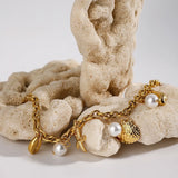 Gold ocean theme bracelet for women with gold chain, seashell, starfish charms, and pearl accents