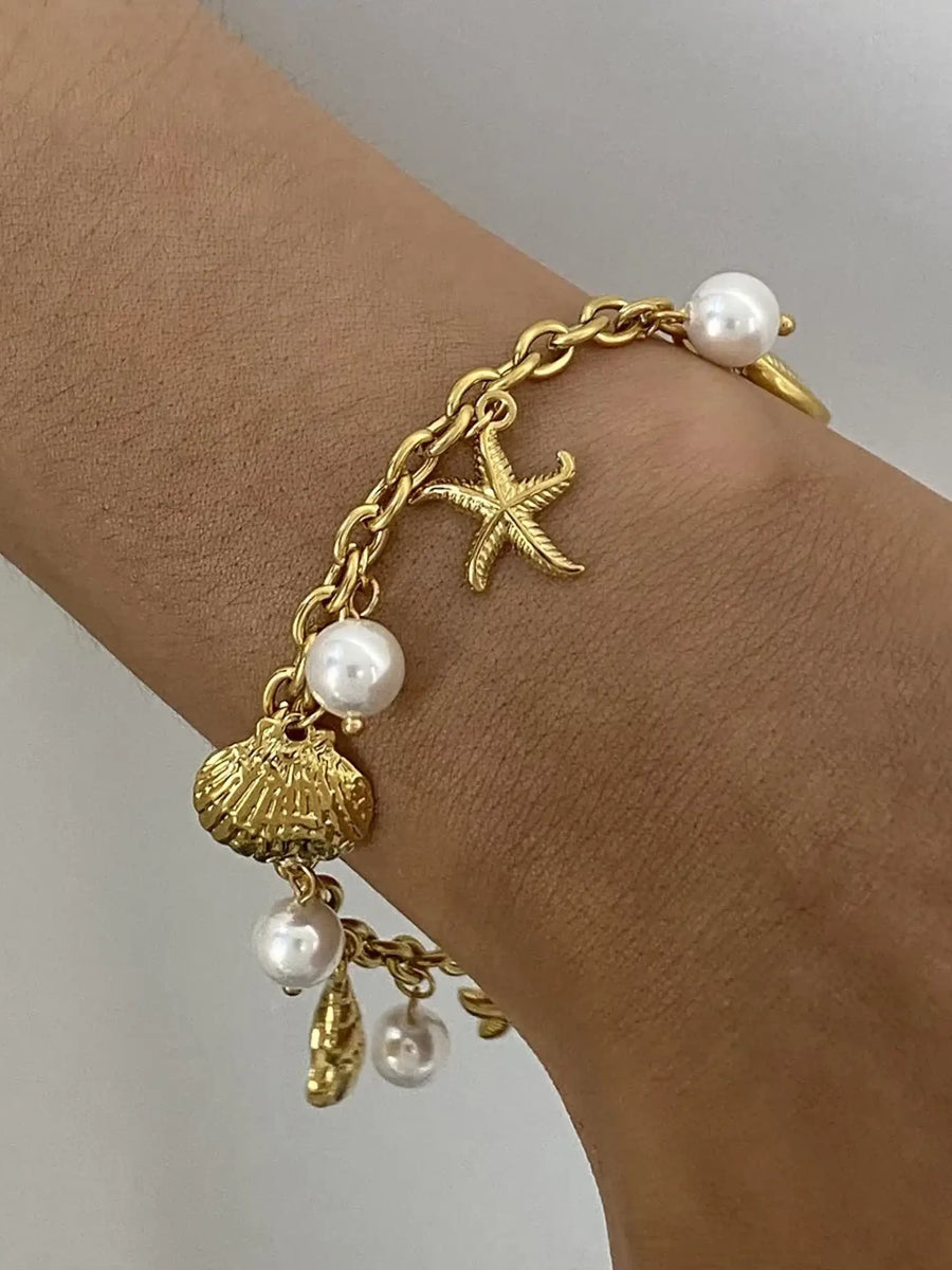 Gold ocean theme bracelet for women with gold chain, starfish charm, seashell charm, and pearls