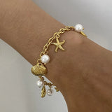 Gold ocean theme bracelet for women with gold chain, starfish charm, seashell charm, and pearls