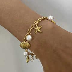 Gold ocean theme bracelet for women with gold chain, starfish charm, seashell charm, and pearls