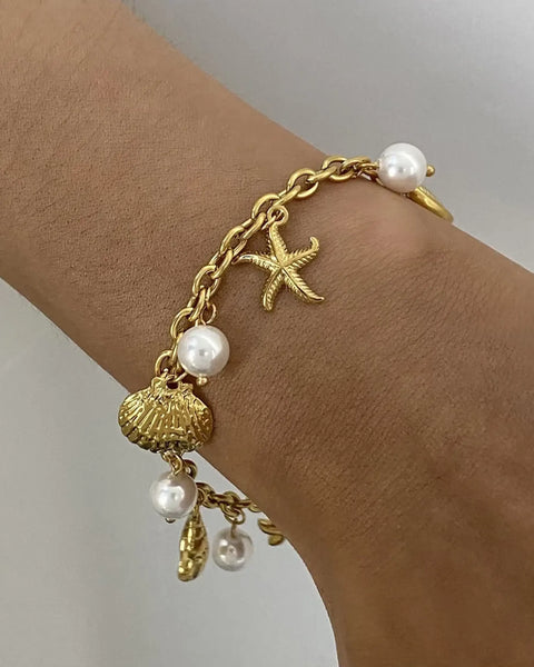 Gold ocean theme bracelet for women with gold chain, starfish charm, seashell charm, and pearls
