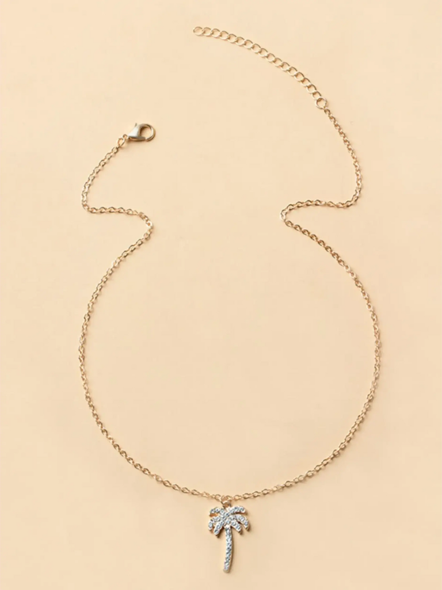 Trendsi gold chain palm tree pendant necklace with rhinestone accents on beige background