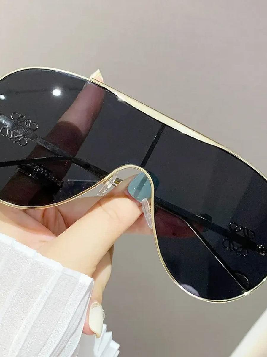Trendsi gradient aviator sunglasses for women with black lenses and gold frame held in hand
