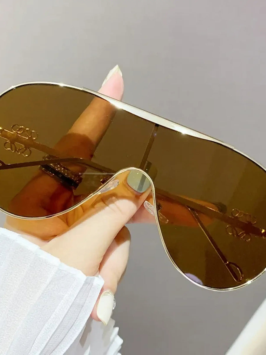 Trendsi gradient aviator sunglasses for women with brown lenses and a gold frame held in hand