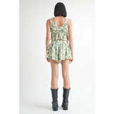 Back view of model wearing Emory Park green tropical flutter shorts with matching top and black boots