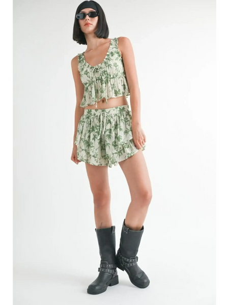 Woman wearing Emory Park green tropical flutter shorts with matching sleeveless top and black boots