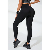 Babe Beachwear black high waisted leggings worn by model with black athletic shoes and wristband