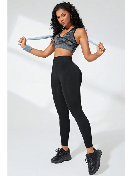 Woman wearing Babe Beachwear black high waisted leggings with black sports shoes and gray sports bra