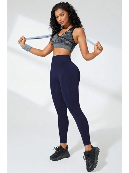 Woman wearing Babe Beachwear black high waisted leggings and sports bra holding fitness towel