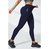 Babe Beachwear black high waisted leggings worn by woman stretching the waistband with athletic shoes