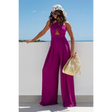 Babe Beachwear halter neck wide leg jumpsuit in bright purple worn with a scarf and sunglasses