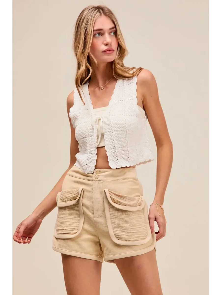 Trendsi high rise cargo shorts in beige with large front pockets worn by woman with white crochet tank top