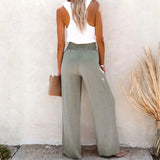 Woman wearing Babe Beachwaer high waisted beach pants set in light green with a white sleeveless top