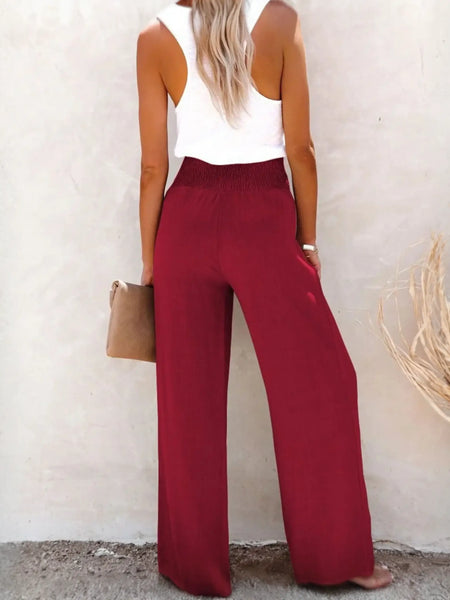 Babe Beachwaer high waisted beach pants set in red with wide legs worn by woman with white tank top