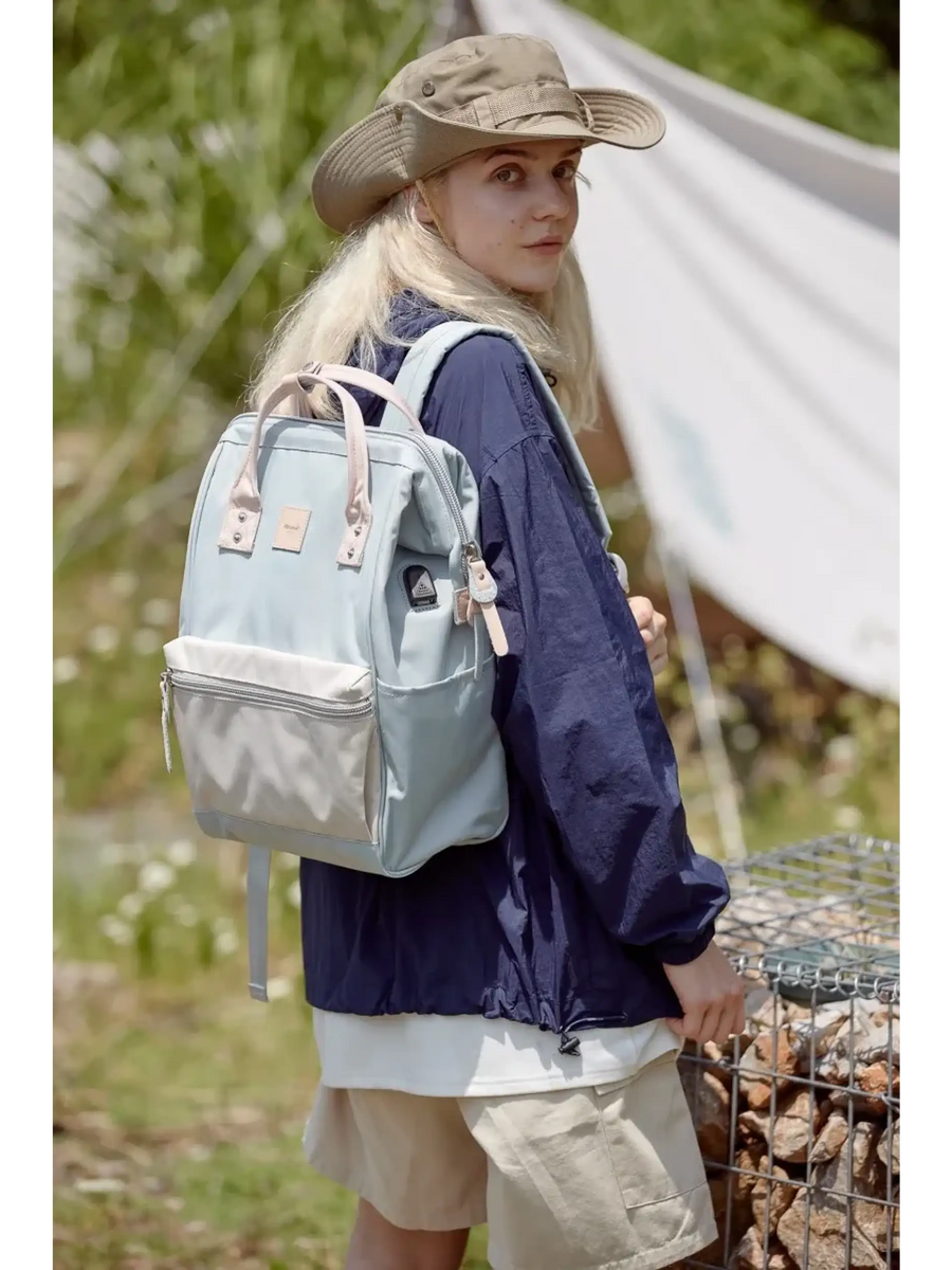 Woman wearing Himawari - Best Backpack by Babe Beachwaer in light blue outdoors with hiking gear