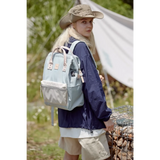 Woman wearing Himawari - Best Backpack by Babe Beachwaer in light blue outdoors with hiking gear