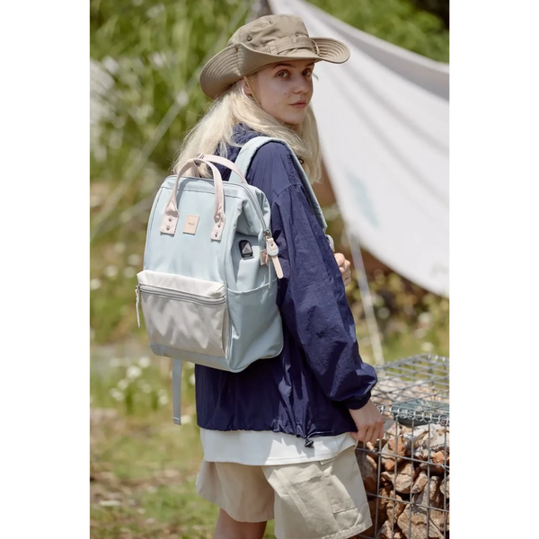 Woman wearing Himawari - Best Backpack by Babe Beachwaer in light blue outdoors with hiking gear