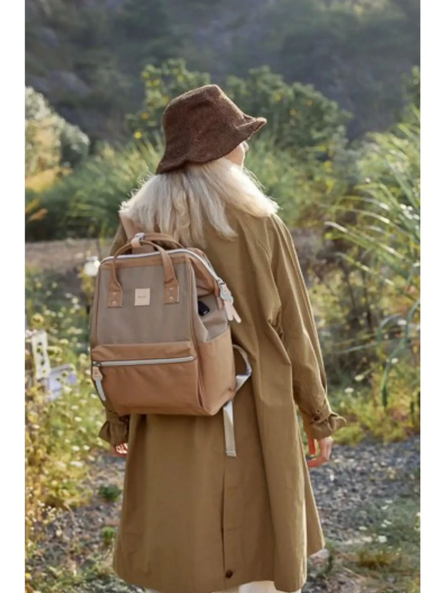 Woman wearing brown Himawari - Best Backpack by Babe Beachwaer outdoors with a brown hat and coat