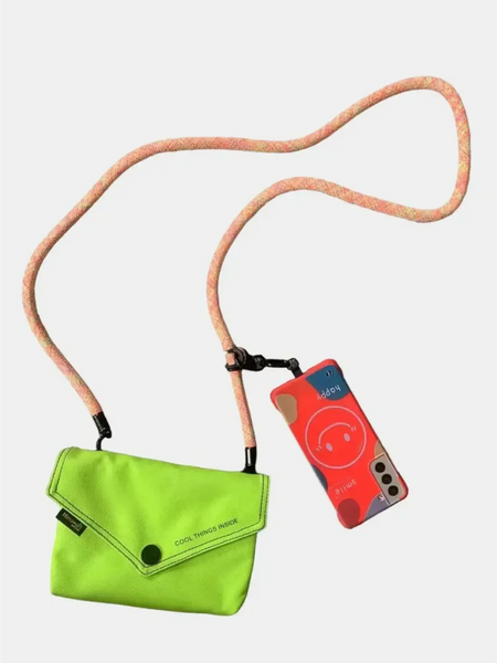 Babe Beachwaer Himawari Crossbody Phone Wallet in bright green with long strap holding a phone