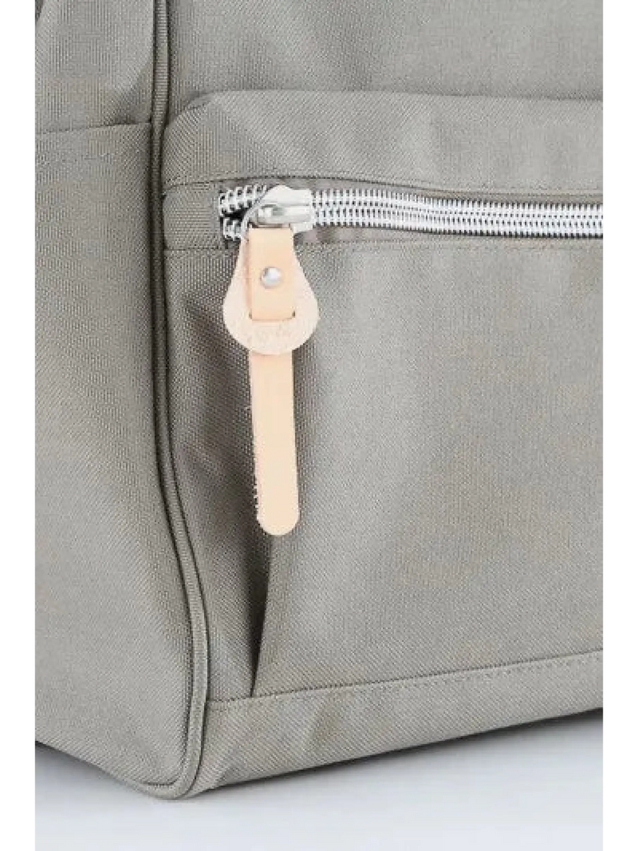 Close-up of gray himawari durable backpack with silver zipper and beige leather pull tab