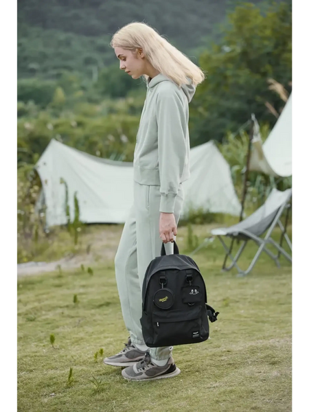 Woman holding a medium beach backpack for school or travel by Babe Beachwaer outdoors