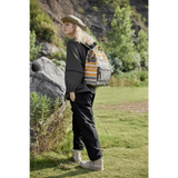 Woman wearing Himwari Large waterproof backpack striped in outdoor nature setting with casual black outfit