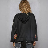 Black hooded cropped sweatshirt with floral sleeve accents for a trendy peace vibe style