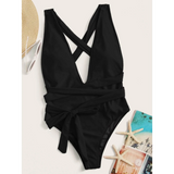 Trendsi black swimsuit with cross back and waist tie alongside sunglasses straw hat and starfish with beach book