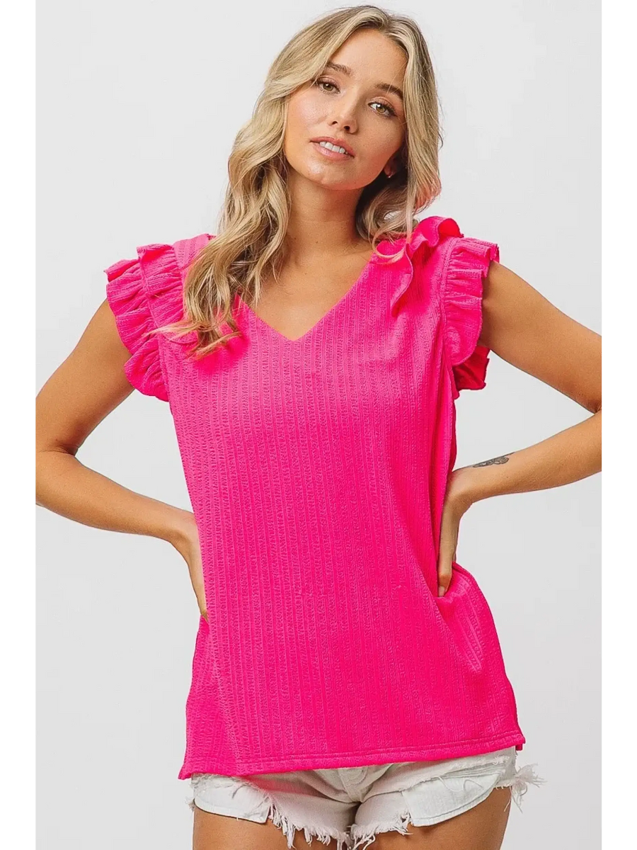 Trendsi hot pink ruffle blouse sleeveless shirt with v-neck worn by model with blonde hair and white shorts