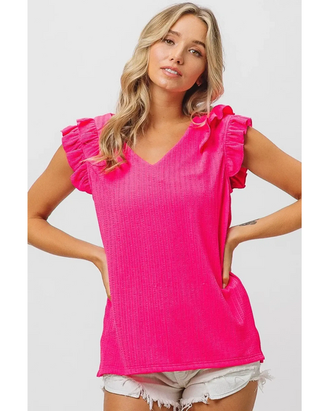 Trendsi hot pink ruffle blouse sleeveless shirt with v-neck worn by model with blonde hair and white shorts