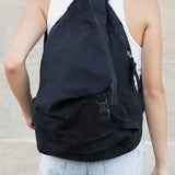 Babe Beachwaer Kai Asymetric Canvas Backpack in black worn by person in white tank top and jeans