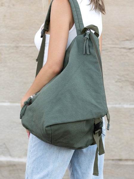 Kai Asymetric Canvas Backpack in olive green worn by a person with casual outfit