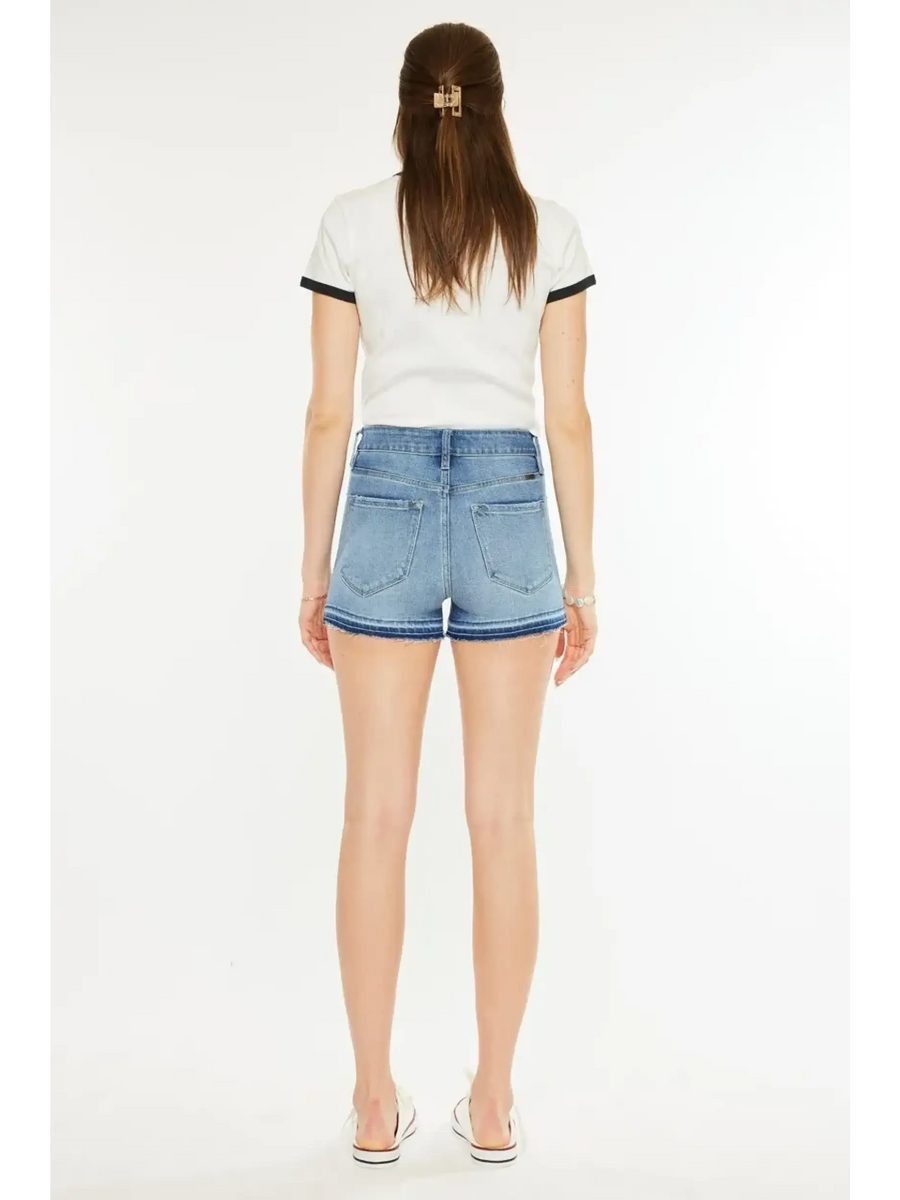 Woman wearing blue denim kancan button fly cutoff shorts from Trendsi, shown from the back