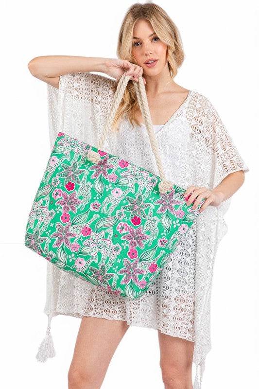 Large floral beach bag for women with green and pink flower print held by woman in white beach cover-up