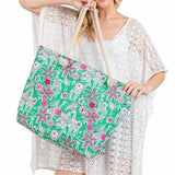 Large floral beach bag for women with green and pink flower print held by woman in white beach cover-up