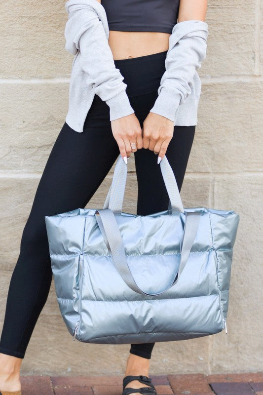 Babe Beachwaer large lightweight puffer weekends silver bag held by woman in casual outfit