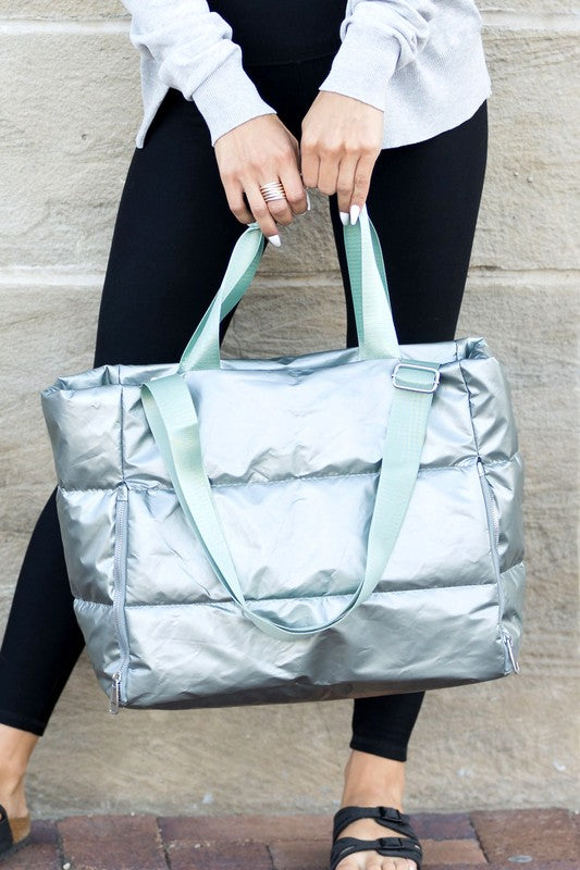 Babe Beachwear large lightweight puffer weekends tote bag in metallic silver held by woman