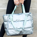 Babe Beachwear large lightweight puffer weekends tote bag in metallic silver held by woman