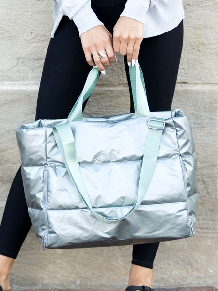 Babe Beachwear large lightweight puffer weekends tote bag in metallic silver held by woman