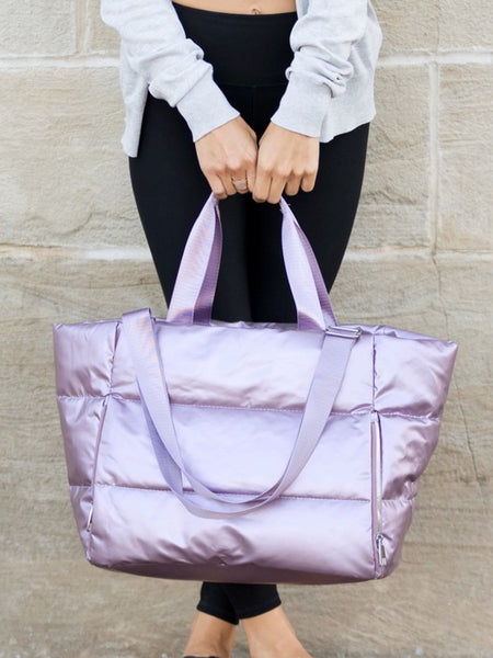 Babe Beachwear large lightweight puffer weekends bag in shiny lavender held by person in casual wear