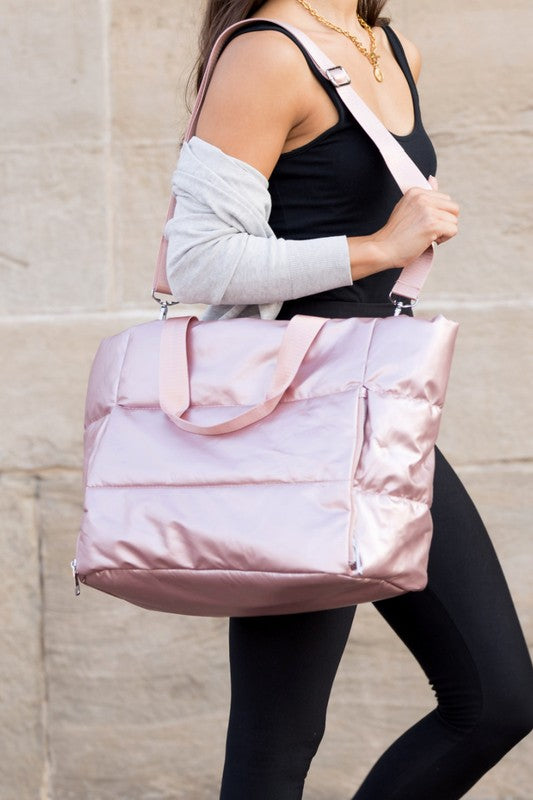 Babe Beachwaer large lightweight puffer weekends bag in shiny pink carried by woman with adjustable strap