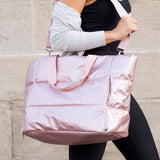 Babe Beachwaer large lightweight puffer weekends bag in shiny pink carried by woman with adjustable strap