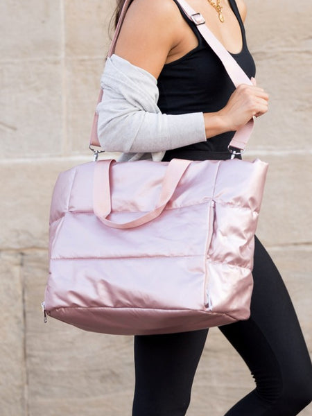 Babe Beachwaer large lightweight puffer weekends bag in shiny pink carried by woman with adjustable strap
